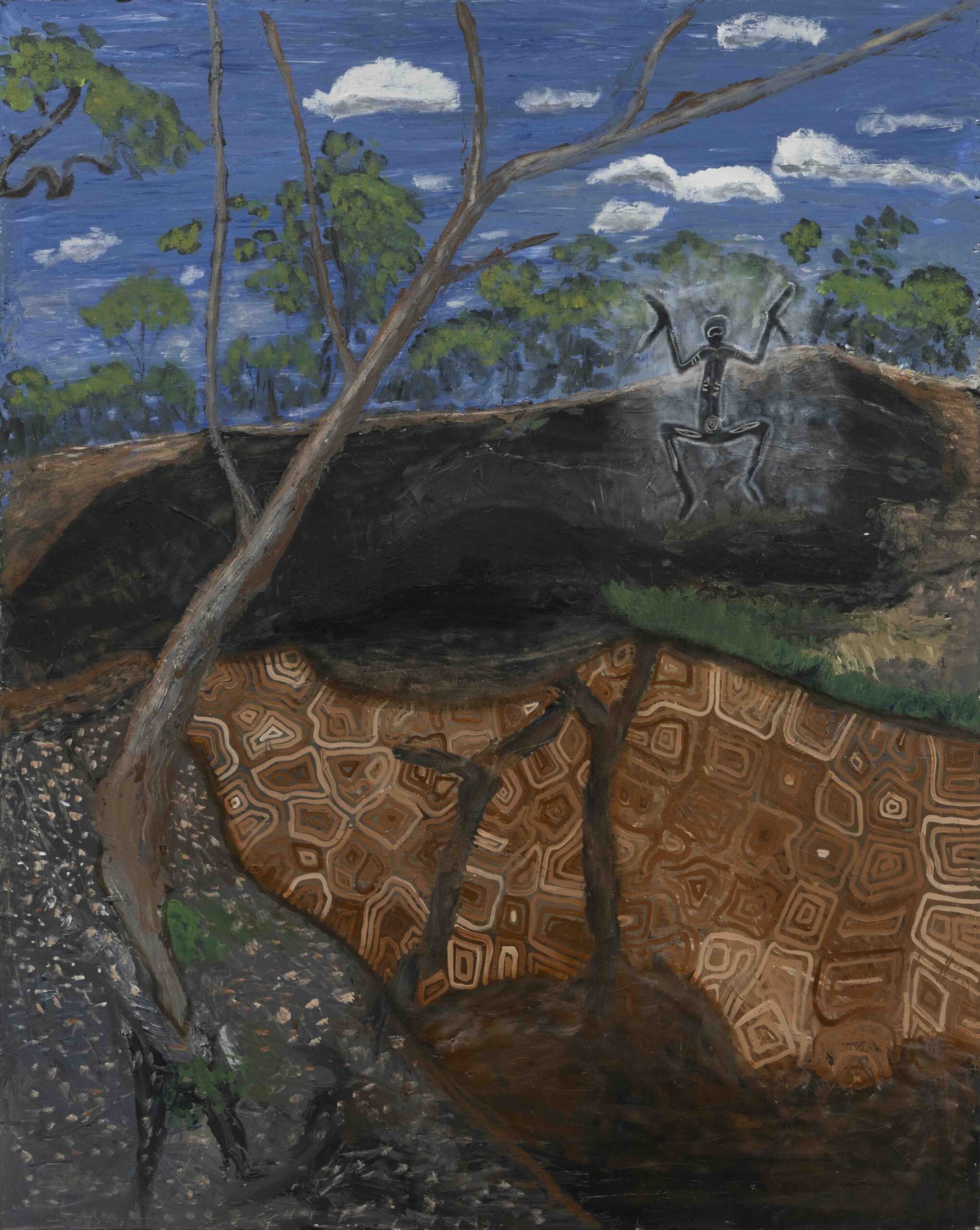 Blue sky with scattered clouds over a forested hillside; a dark, carved figure with raised arms sits on the slope amid trees and branches.